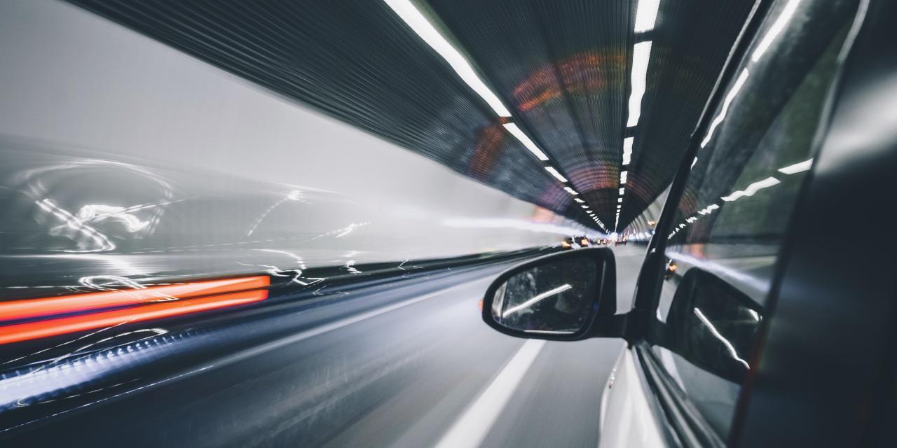 Rearview mirror of a fast-moving car in a tunnel